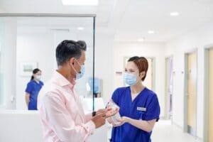 Nurse and patient wearing facemasks to protect against COVID-19