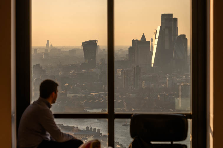 Person looking out of window at City of London skyline